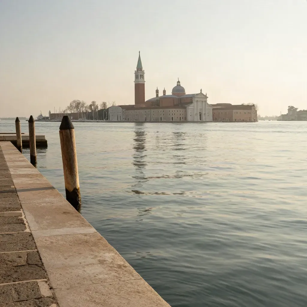 Laguna veneta al tramonto con basilica lontana, acqua calma e molo in pietra